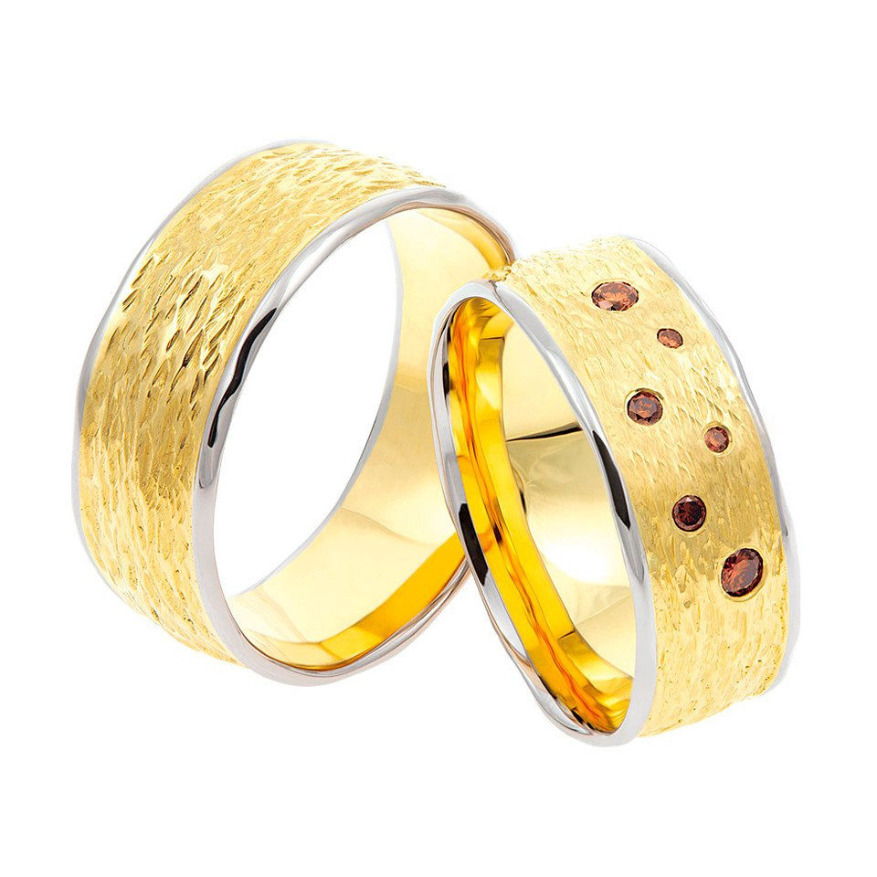 twee trouwringen van geel goud met rode diamanten