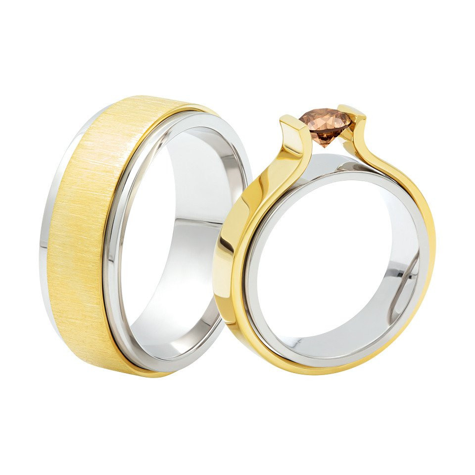 twee trouwringen met een bruine diamant in het midden