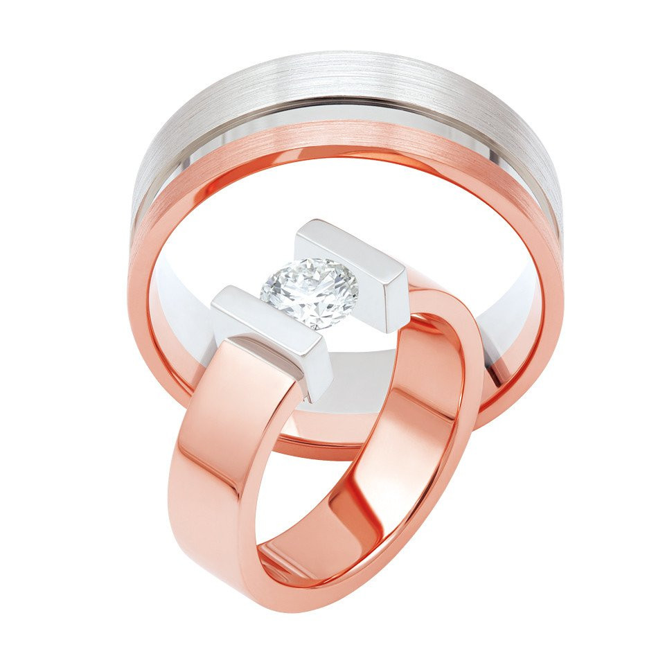 twee roségouden trouwringen met een diamant in het midden