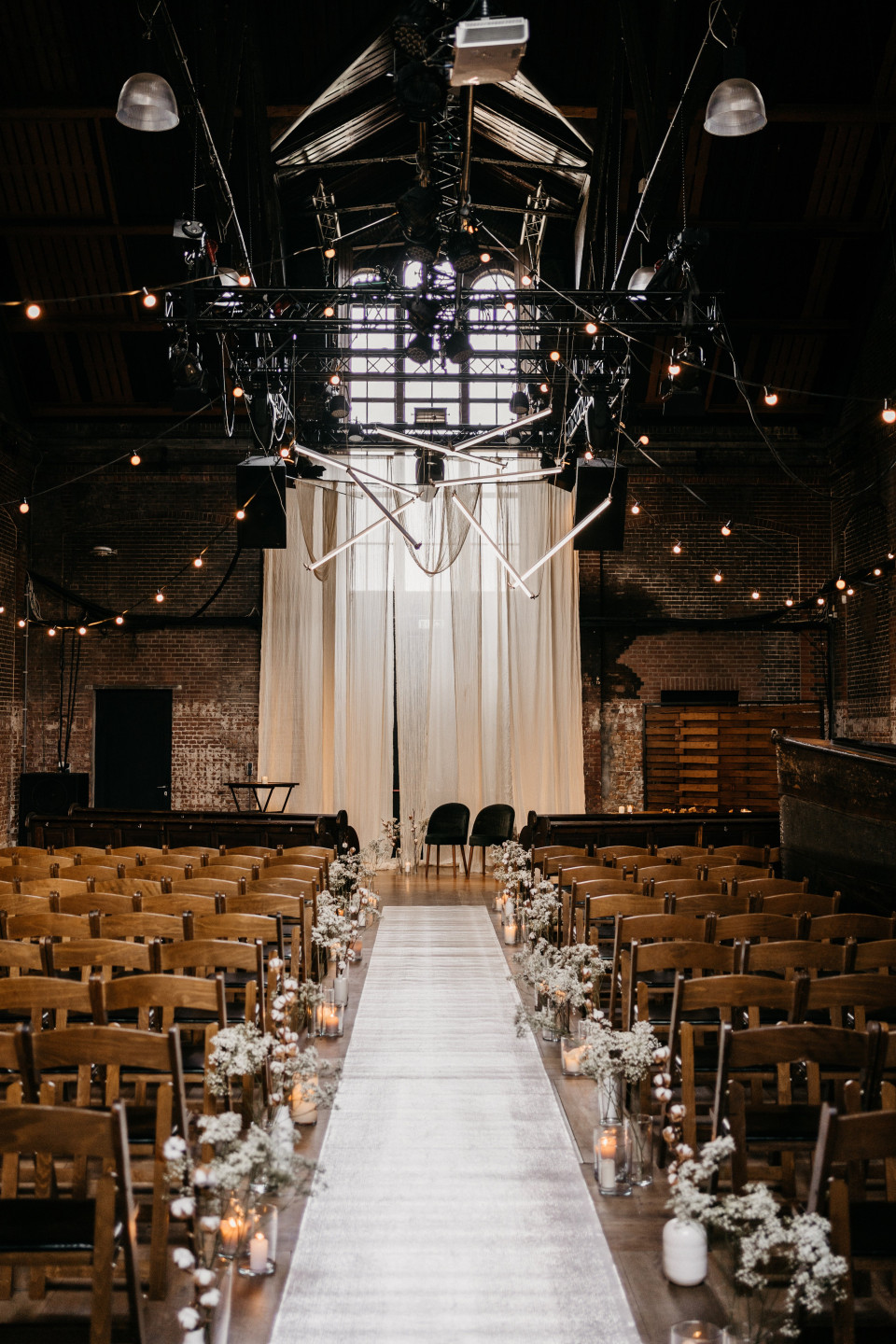een lege trouwceremoniezaal met houten stoelen en kaarsen