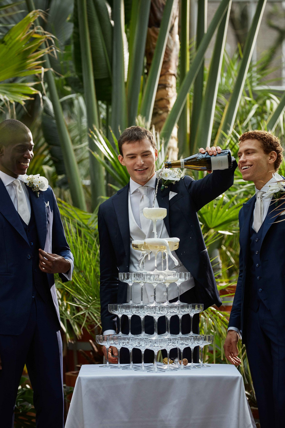 drie mannen in pakken staan naast een taart