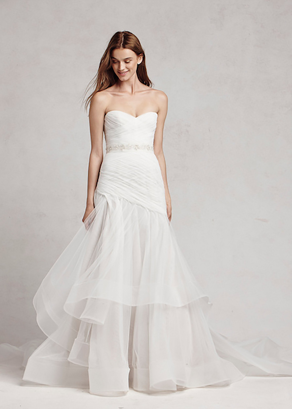 de trouwjurk is een strapless japon met een gerimpelde rok