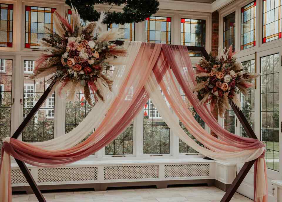 Backdrop met roze draperieën en bloemen met een touch of boho