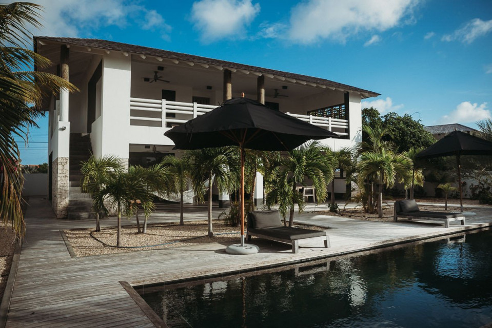 een huis met een zwembad en ligstoelen