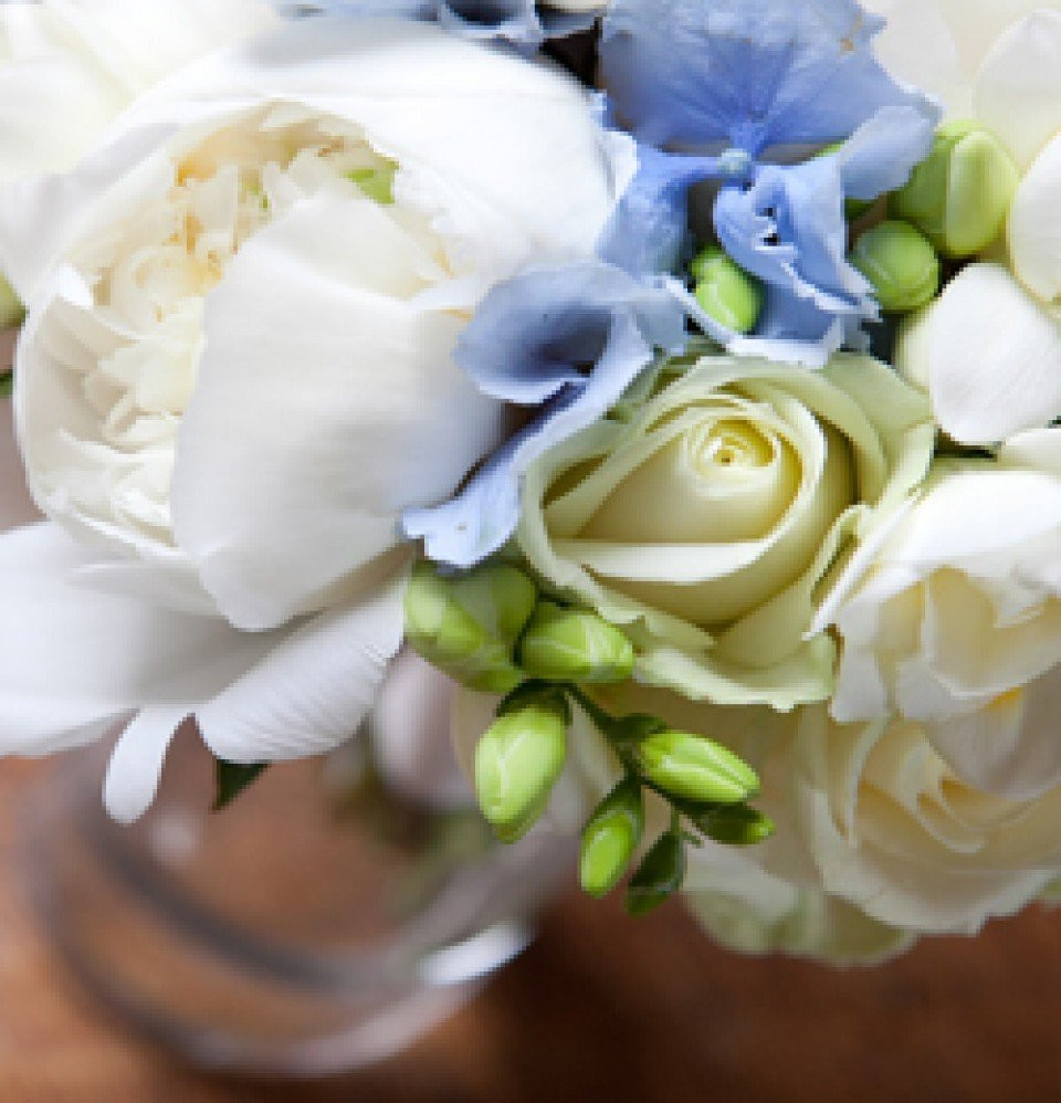 een vaas gevuld met witte en blauwe bloemen