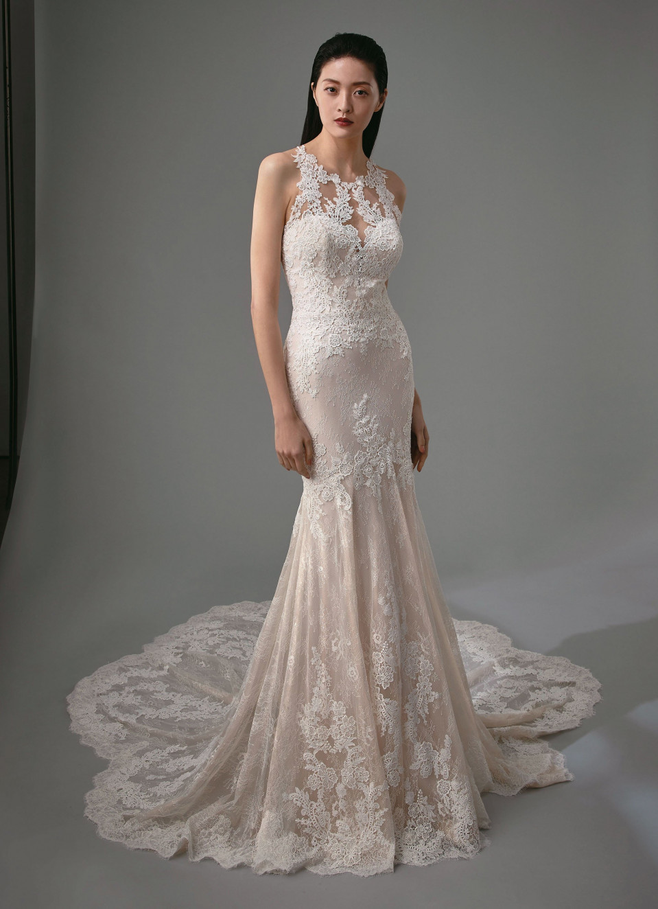 de trouwjurk is gemaakt van kant en heeft een open rug