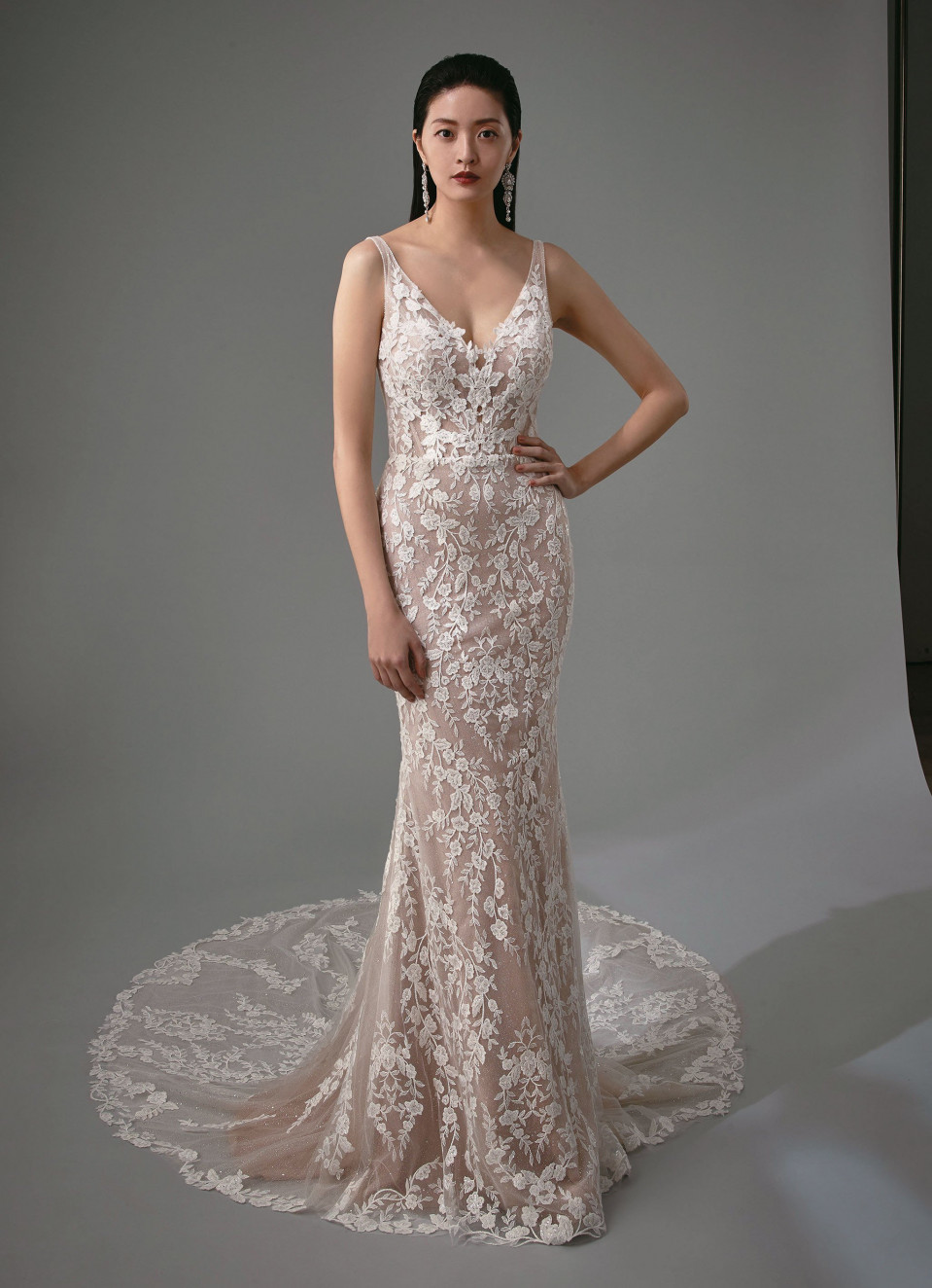 de trouwjurk is gemaakt van kant en heeft een open rug