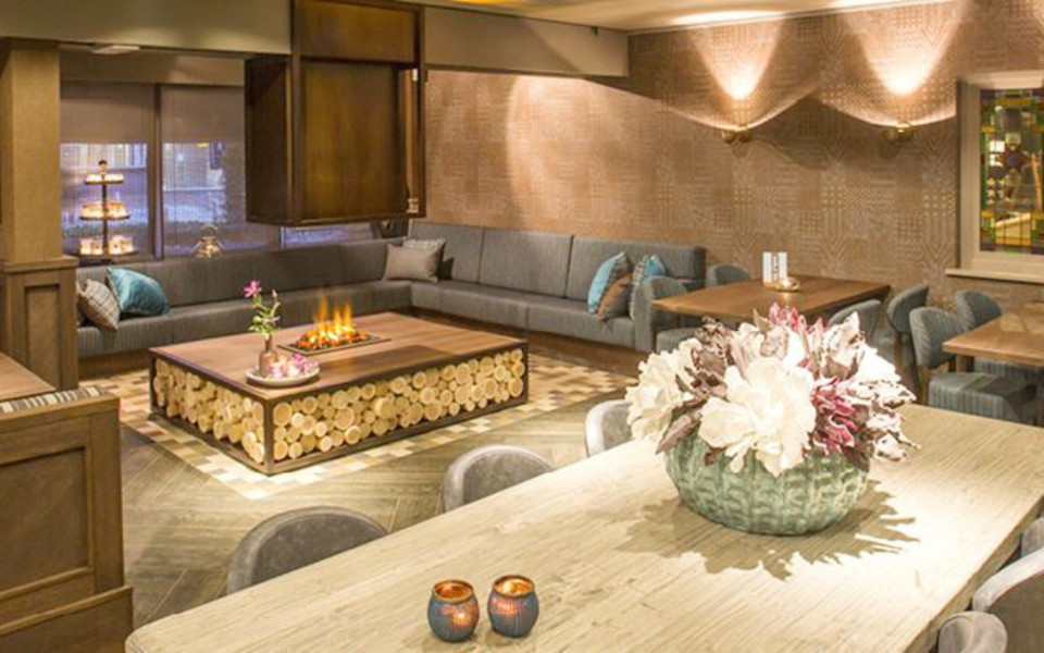 de eetkamer van het hotel is versierd met hout en leer