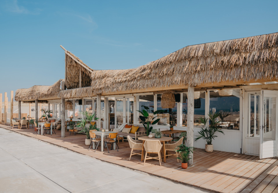 een strandbar met rieten dak en stoelen