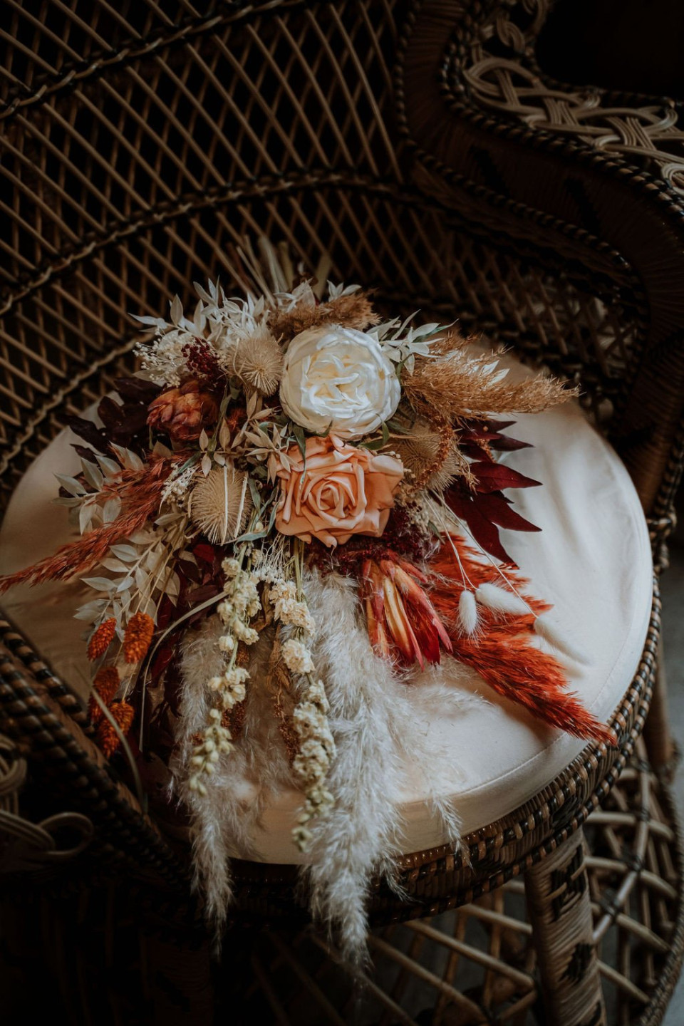 een boeket bloemen dat op een rotanstoel ligt