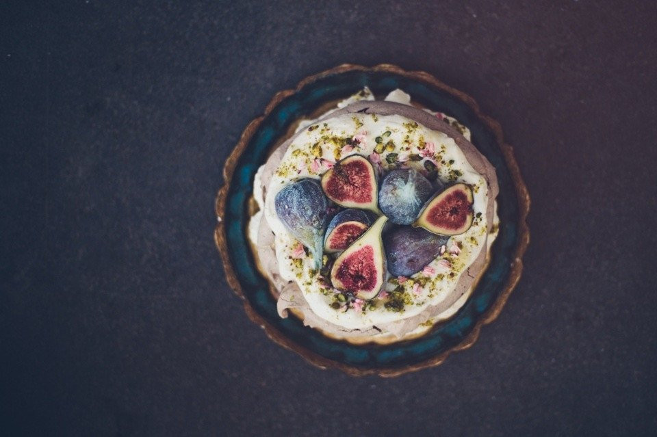 een taart met vijgen en pistachenoten erop