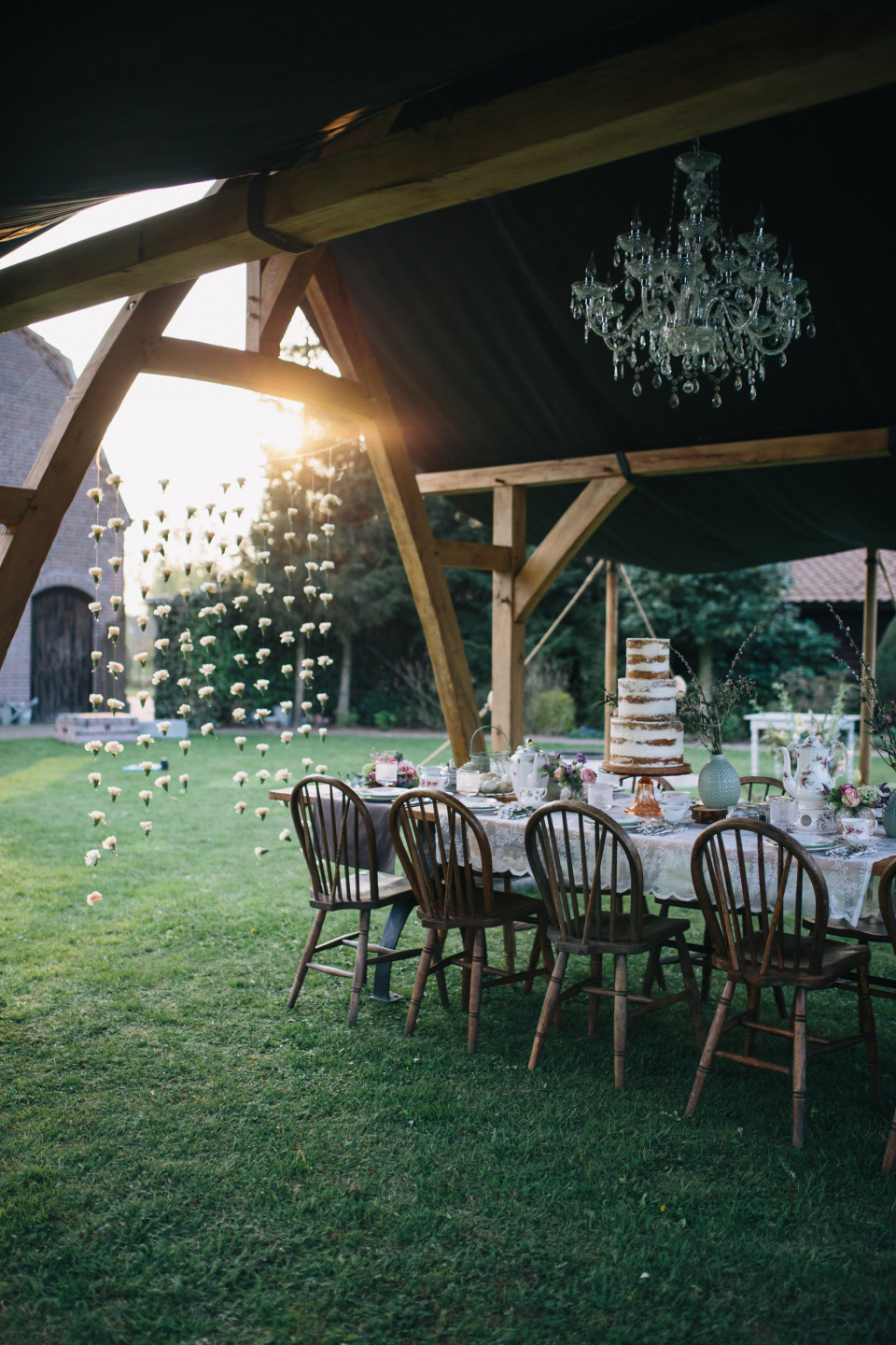 een buitenbruiloftsreceptie met kroonluchters en tafels