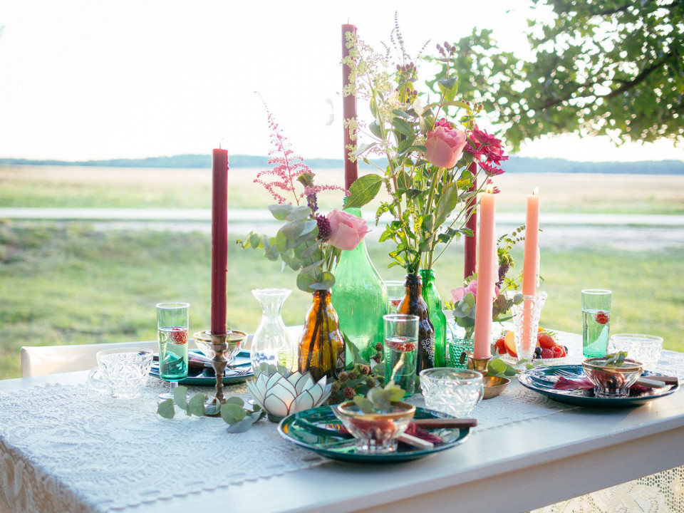 een tafel met kleurrijke bloemen en kaarsen