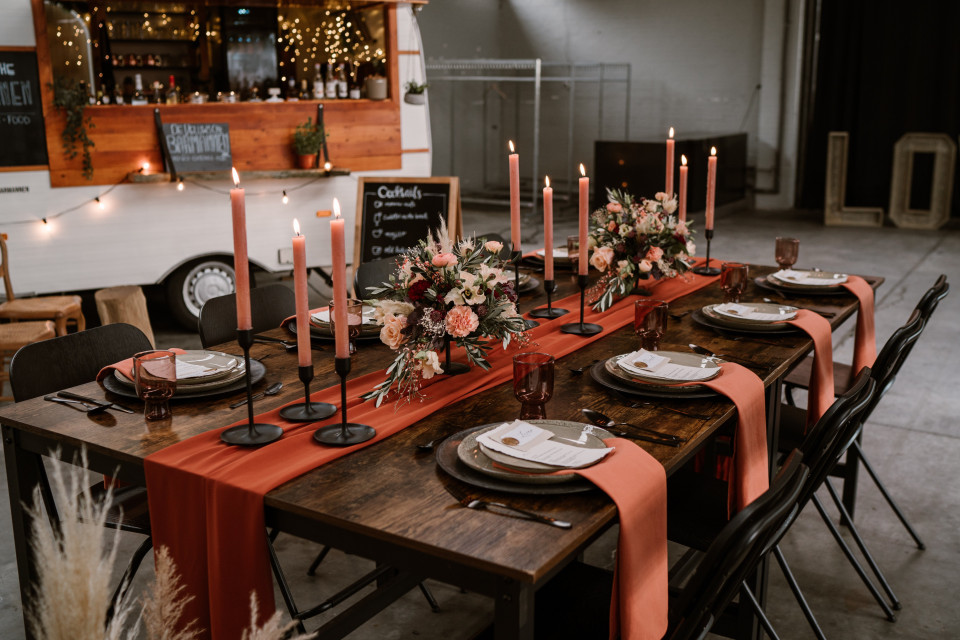 een tafel gedekt voor een dinertje met kaarsen en een rode loper