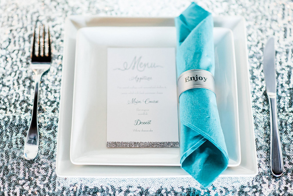 een tafelsetting met bestek en een blauwe servet