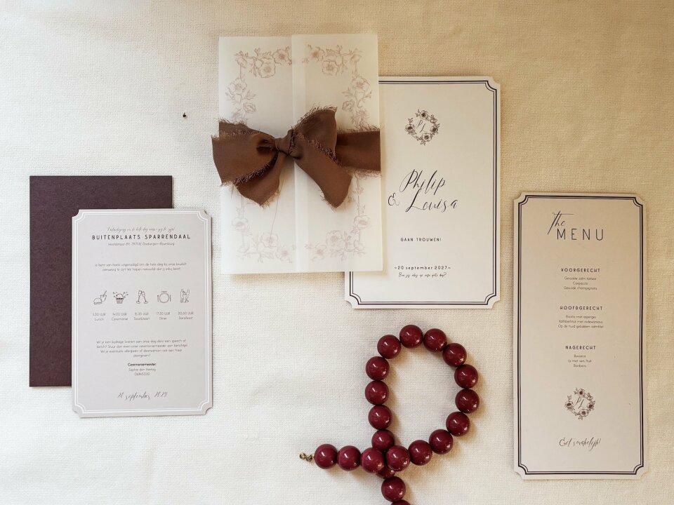 een assortiment trouwstationery-items uitgestald op een tafel