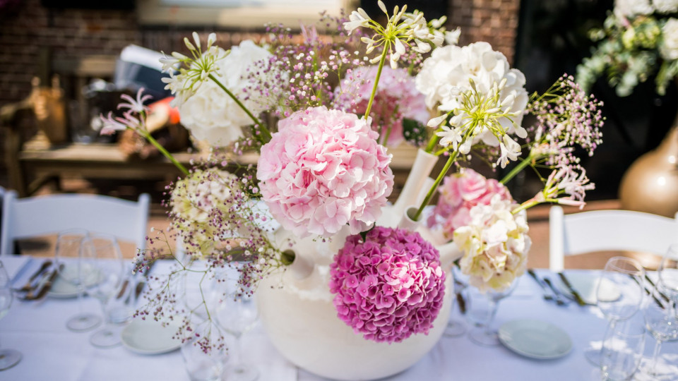 een vaas gevuld met roze en witte bloemen
