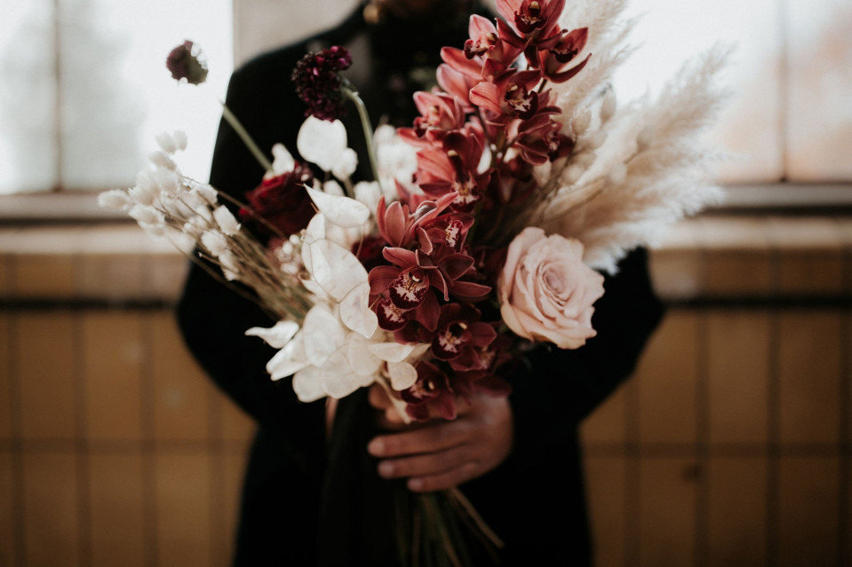 een man die een boeket bloemen vasthoudt