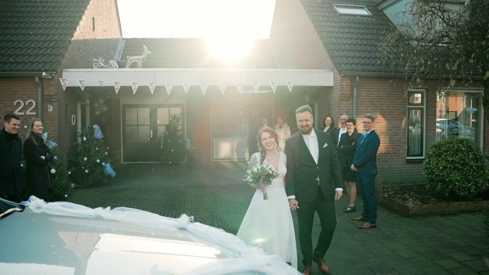 een bruid en bruidegom die het oprit van hun huis aflopen