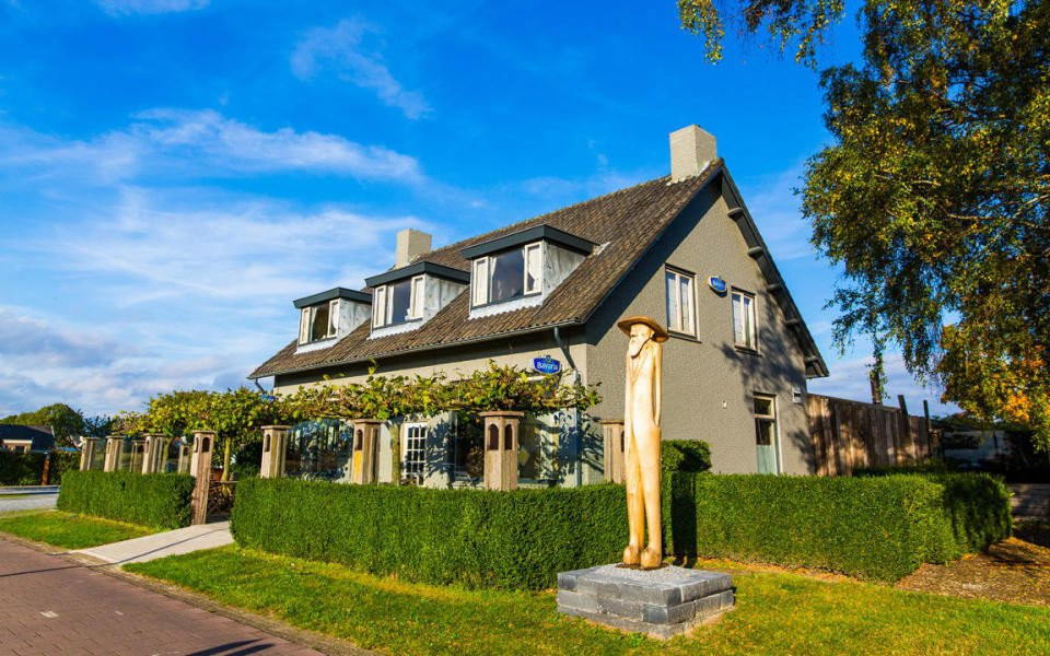 een huis met een standbeeld ervoor