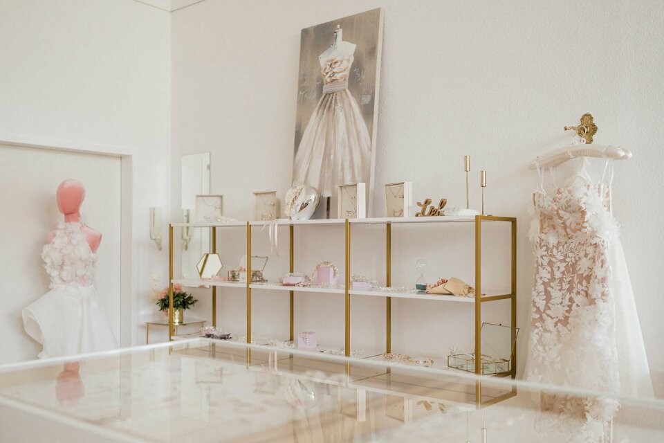 een tentoonstelling van trouwjurken op een plank in een bruidswinkel