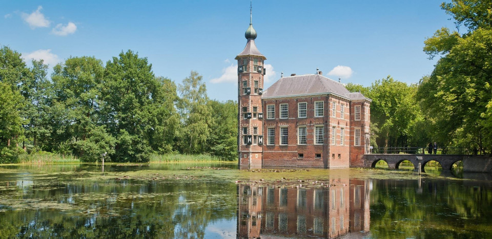 een groot bakstenen gebouw staat op een meer