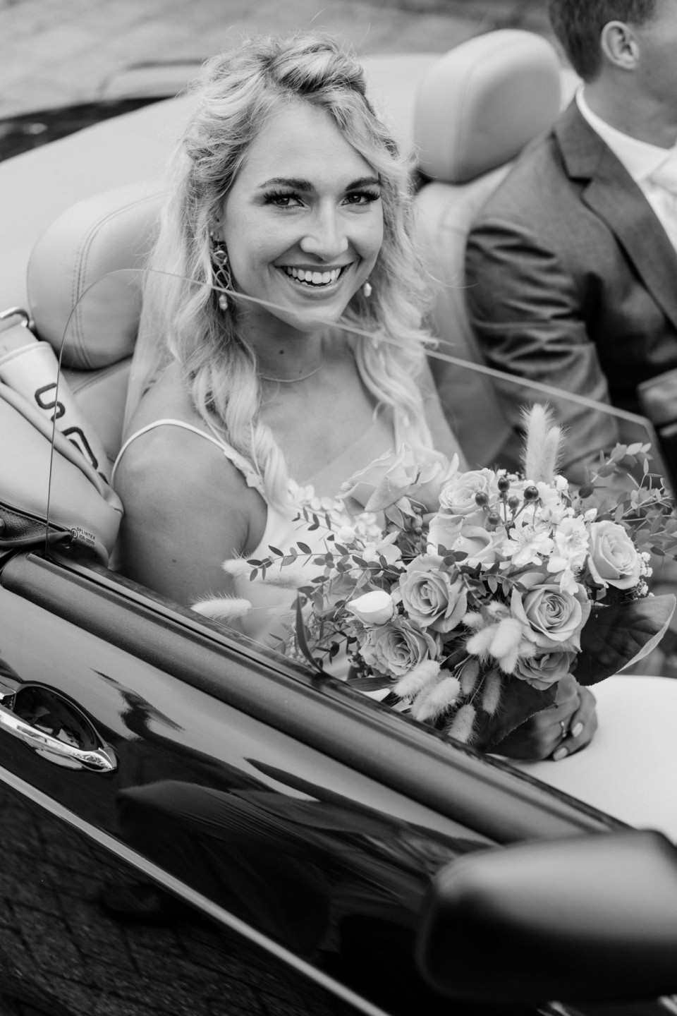 een bruid en bruidegom in een cabriolet auto