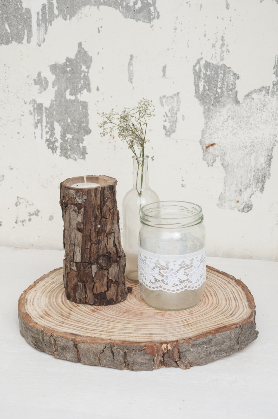 een houten dienblad met een kaars en een pot