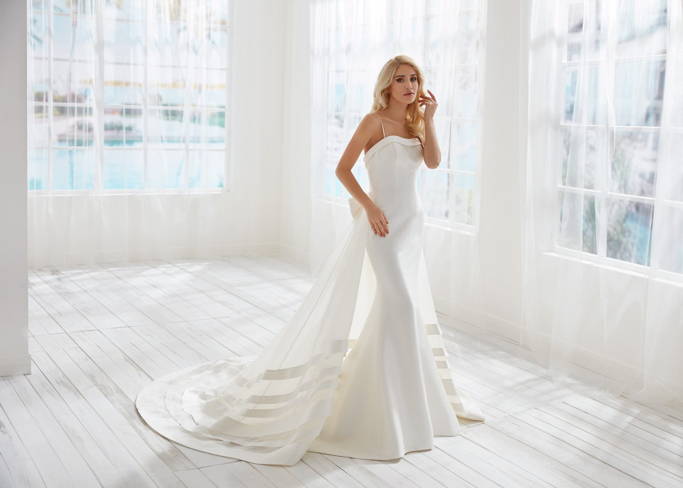 de bruid draagt een strapless trouwjurk met een lange sleep