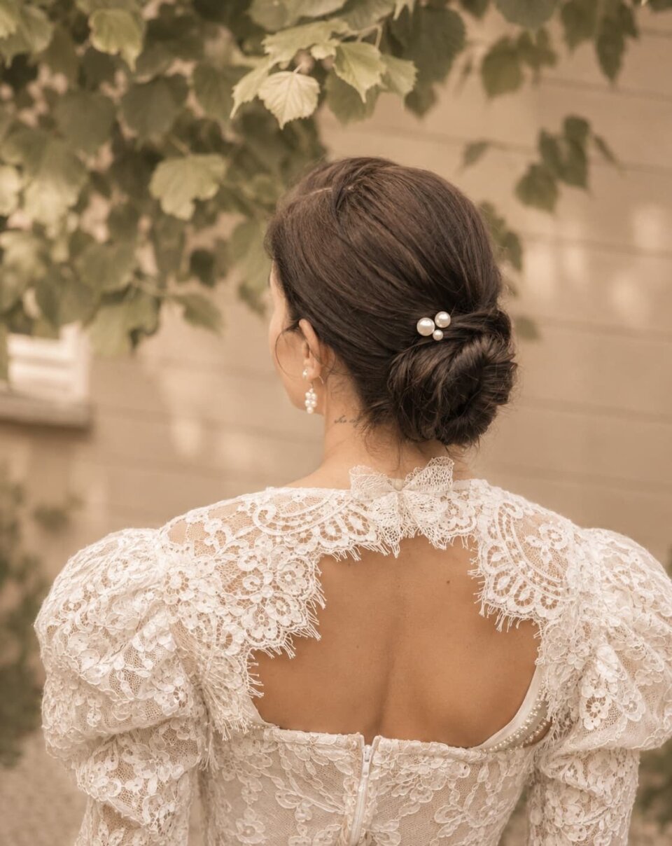 de achterkant van een trouwjurk van een vrouw met een bloem in haar haar