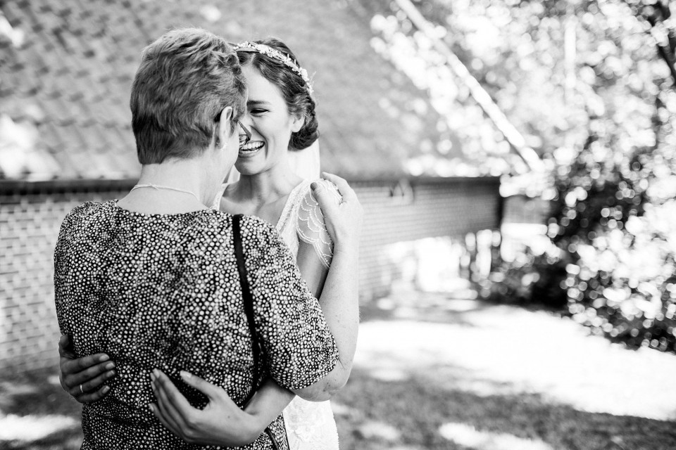 een vrouw die haar moeder omhelst op een bruiloft