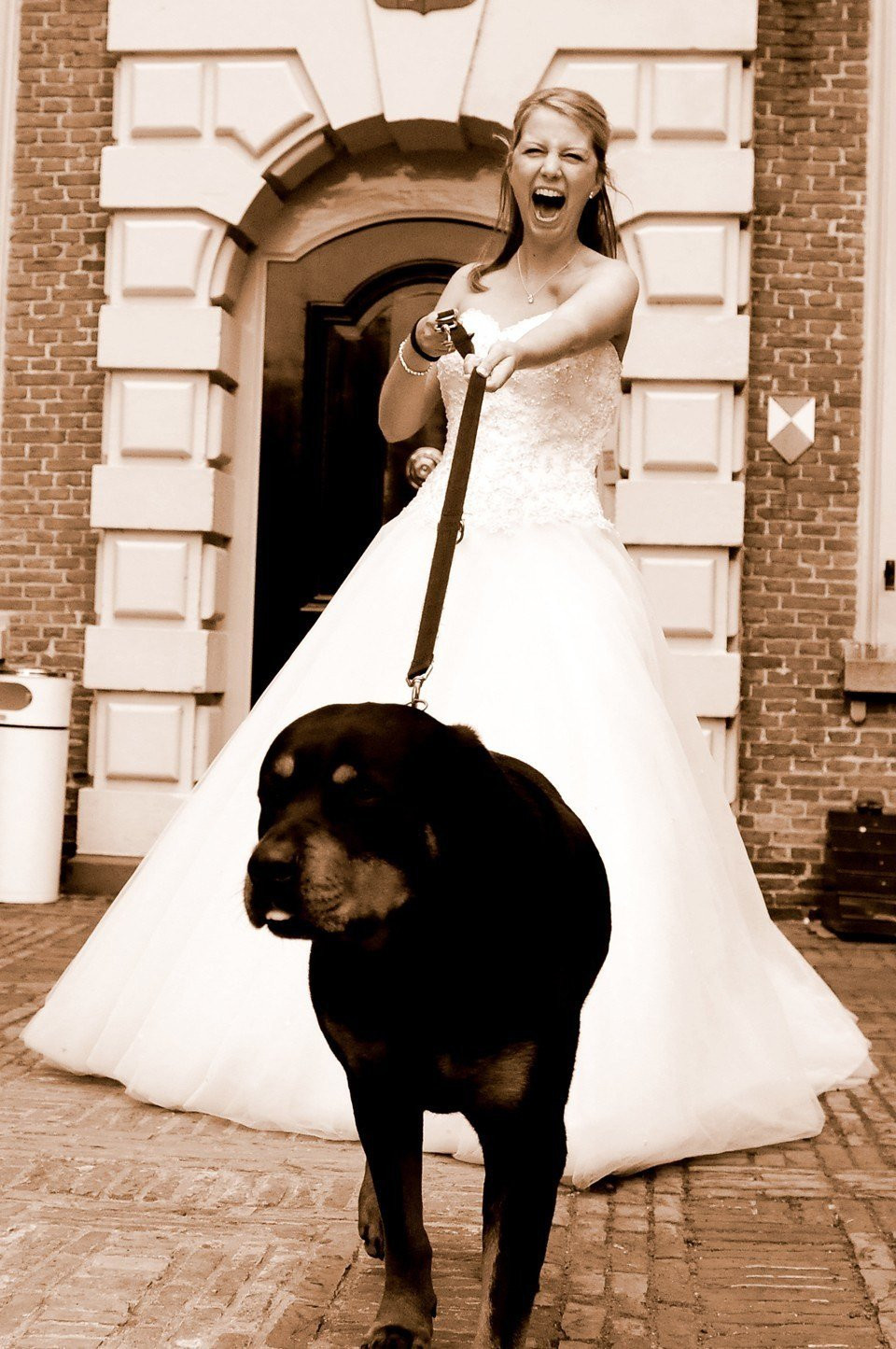 een vrouw in een trouwjurk loopt een hond