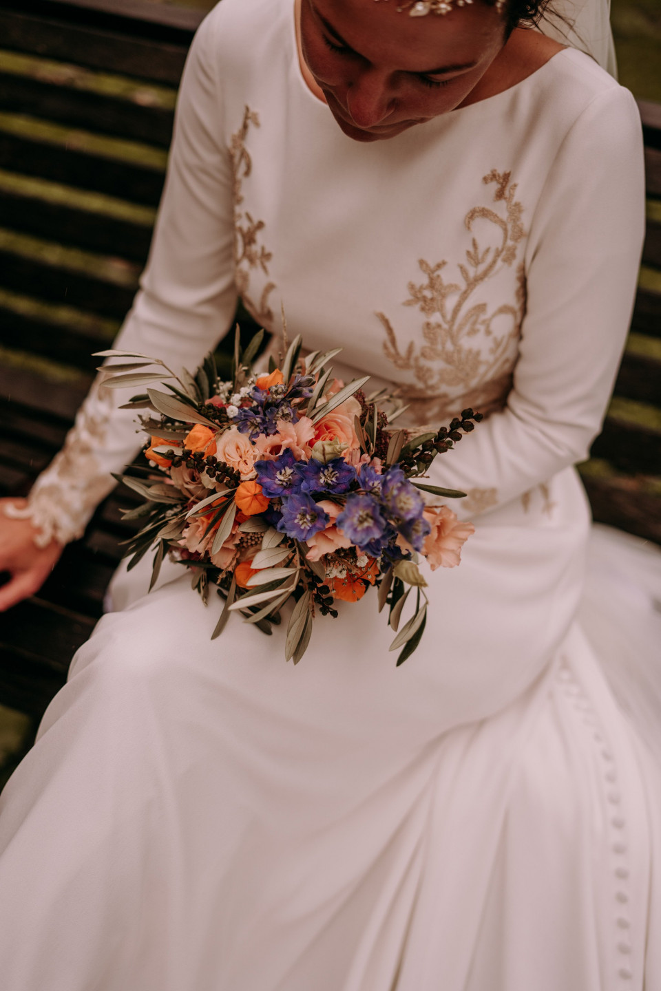 een bruid die op een bank zit met haar boeket