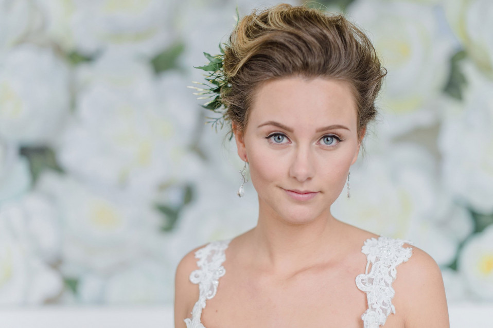 een prachtige bruid in een witte jurk en bloemen