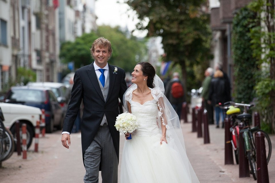 een bruid en bruidegom lopen op straat