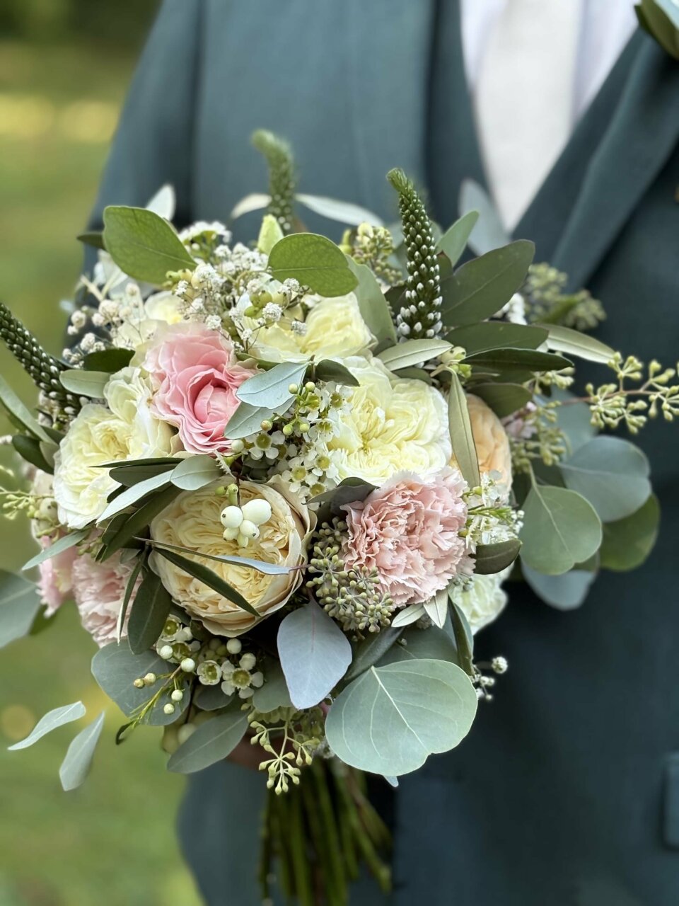 een man in een pak die een boeket bloemen vasthoudt