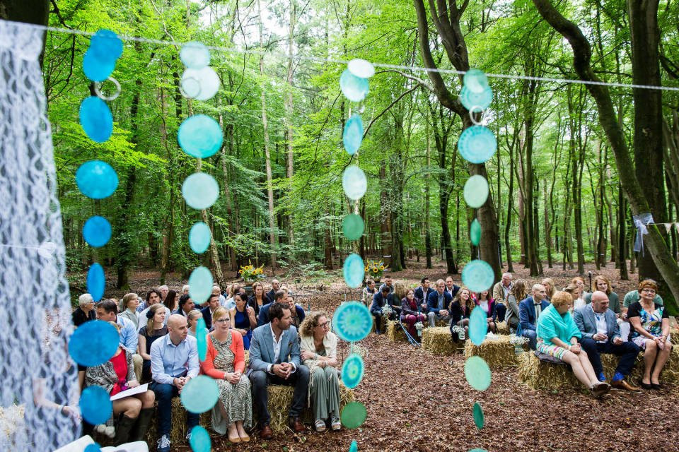 een bruiloftsceremonie in het bos met papieren cirkels