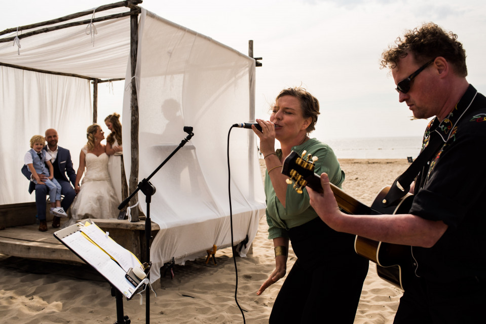 een man en vrouw die op het strand zingen