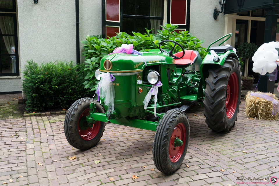 een groene tractor met een wit en paars lint