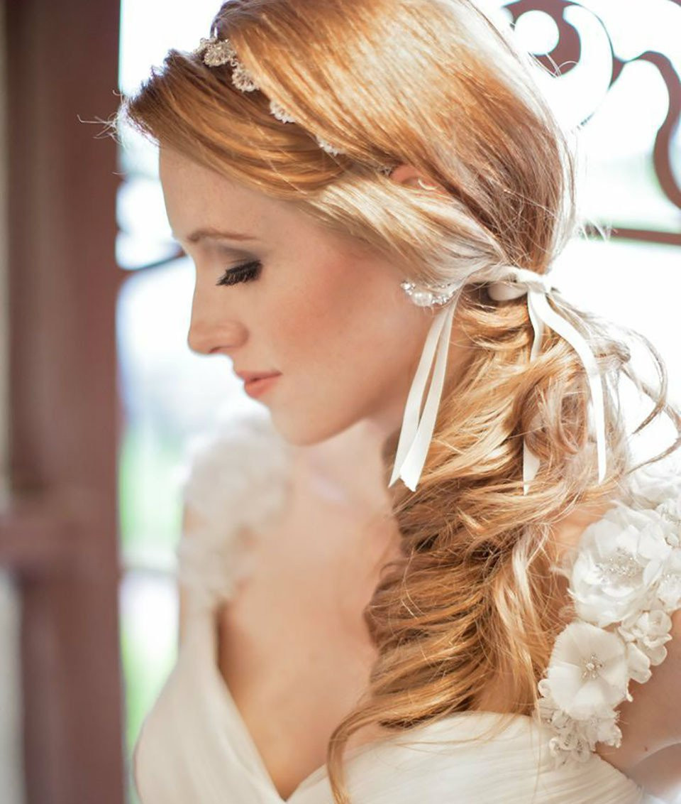 een mooie bruid met lang rood haar die een trouwjurk draagt