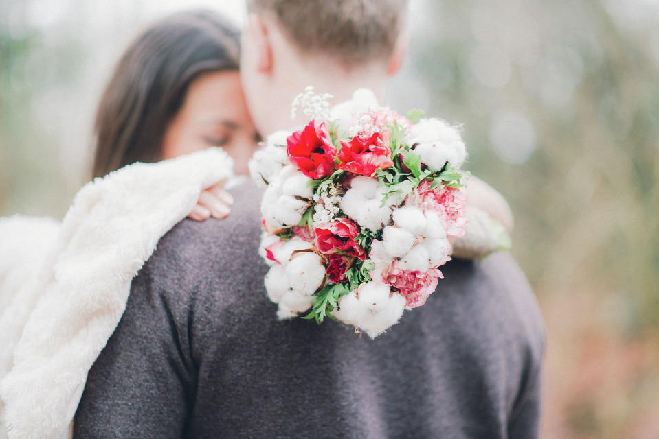 een man en vrouw omhelzen elkaar met een boeket bloemen