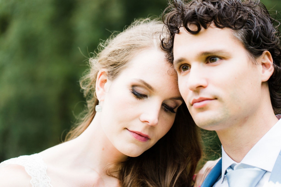 een man en vrouw in trouwkledij poseren voor een portret