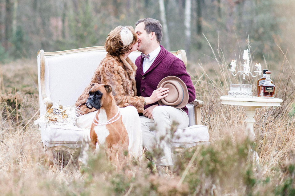 een paar dat kust in een veld met een hond