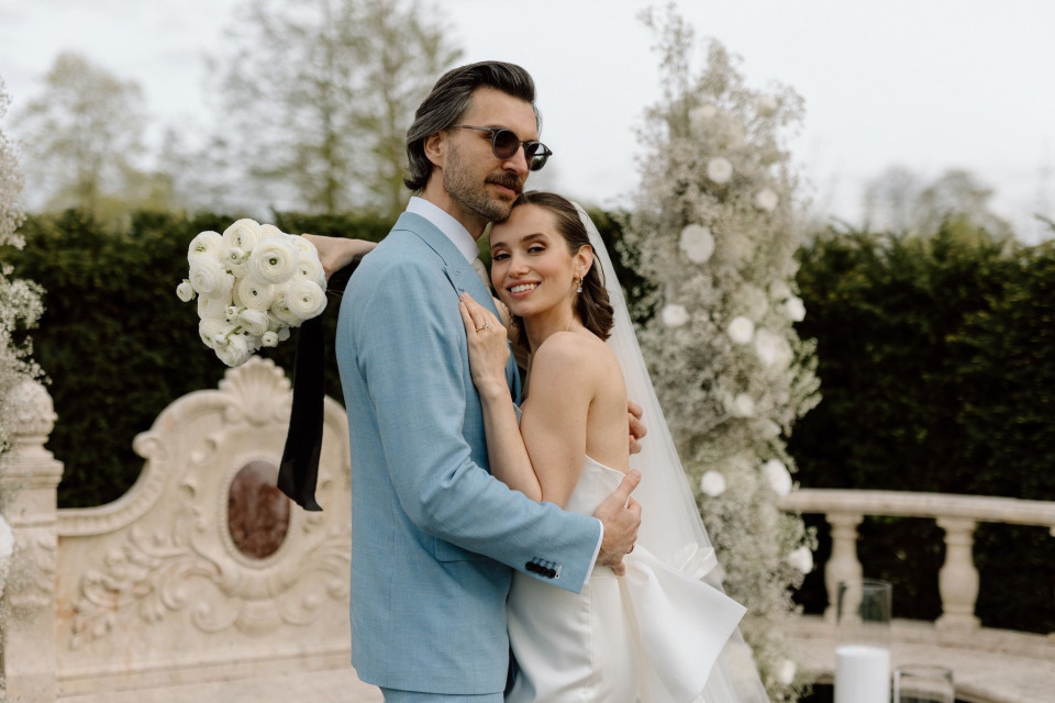 een bruid en bruidegom poseren voor een foto voor een fontein