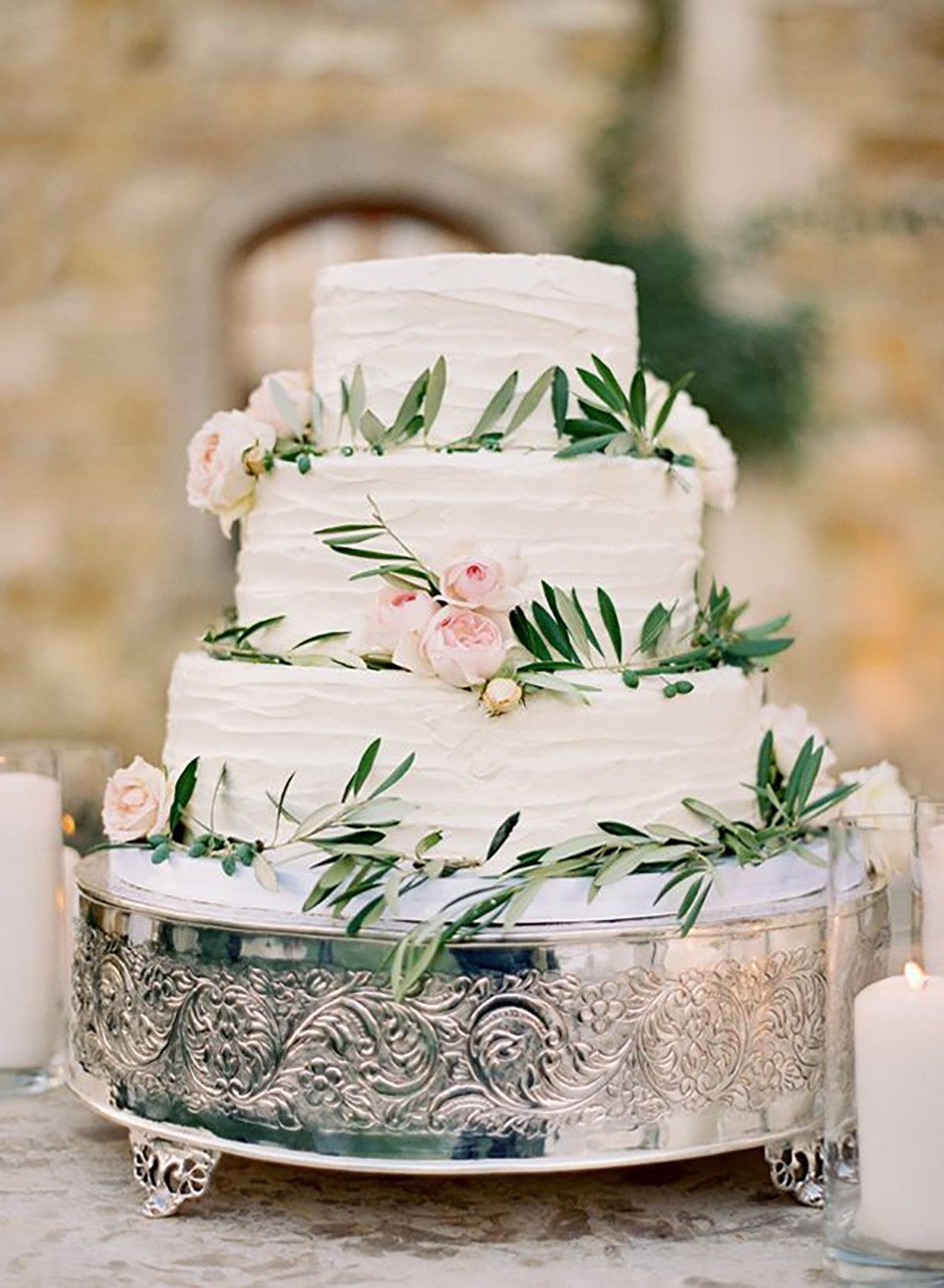 een drielaagse bruidstaart met groen en bloemen
