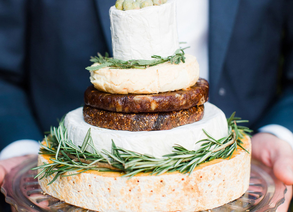 een man die een kaastaart met rozemarijn vasthoudt