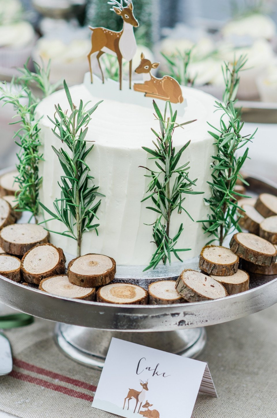 een taart met een hert erop en een houten standaard