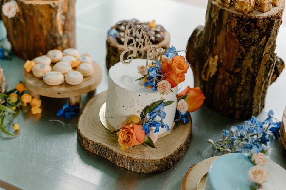 Bruidstaart met kleurrijke bloemendetails en andere zoete snacks