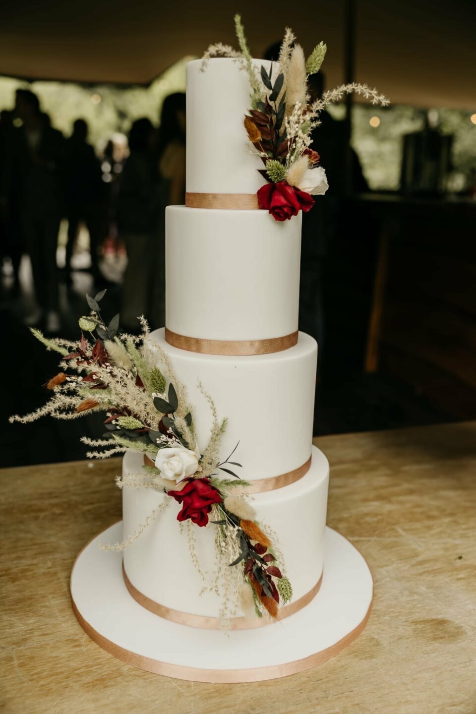 een close-up van een drie-laags taart met bloemen erop
