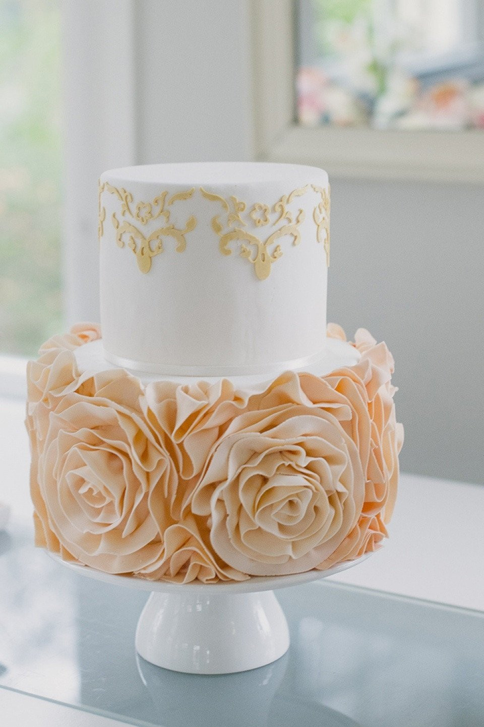 een bruidstaart met gouden rozen erop